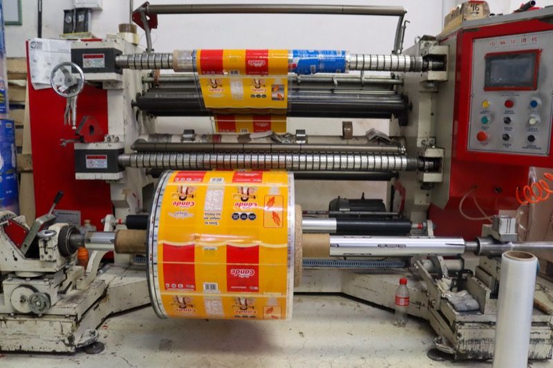 Cortadora rebobinadora con una bobina impresa en amarillo y rojo